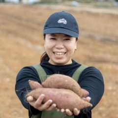 そらファームでとれたさつま芋を掲げる佐藤阿佑美さん